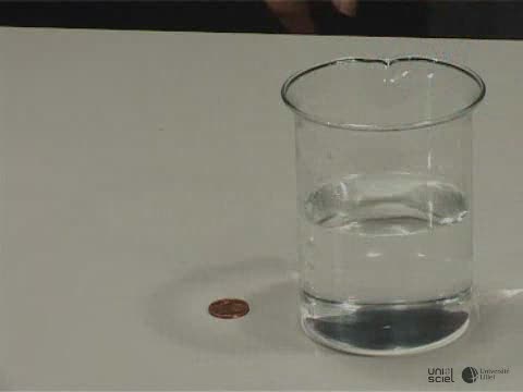 Une pièce de monnaie disparaît sous un verre